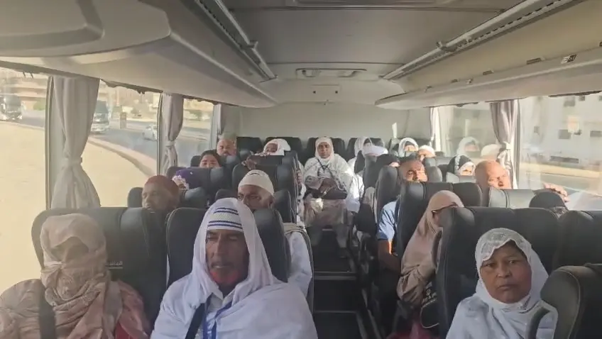 Pilgrims seated inside the air-conditioned coach during group transport