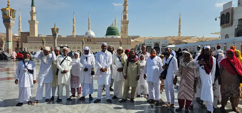 Madni Tour & Travels group at Masjid an-Nabawi with the Green Dome in the background, Madinah