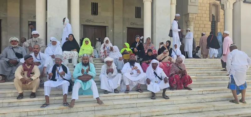 Men and women of the group seated together on mosque steps during Ziyarat